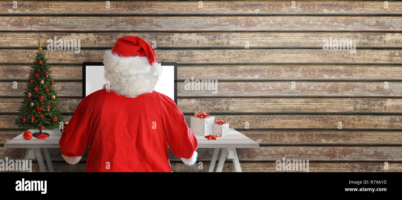 Santa Claus enviar tarjetas de felicitación en línea. Copie el espacio junto a la pared de madera. Foto de stock
