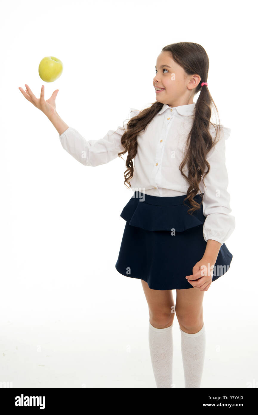 Niño schoolgirl desgaste uniforme formal mantenga apple. Chica linda alumno  mantenga apple puesto de frutas sobre fondo blanco. Niño feliz celebrar  apple. Merienda Escolar concepto. Nutrición saludable dieta. Apple vitamina  snack Fotografía