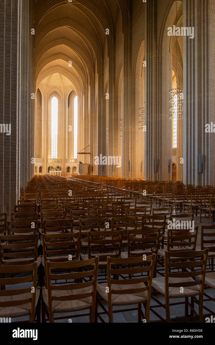 Copenhague, Dinamarca - 18 de septiembre de 2018: Interior de la iglesia (Grundtvigs kirke) con pilares de ladrillo, luz solar y muchas sillas. Foto de stock