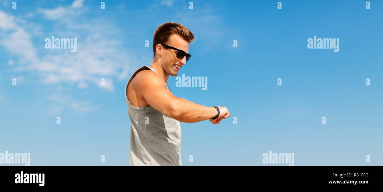 Feliz hombre mirando fitness tracker Foto de stock