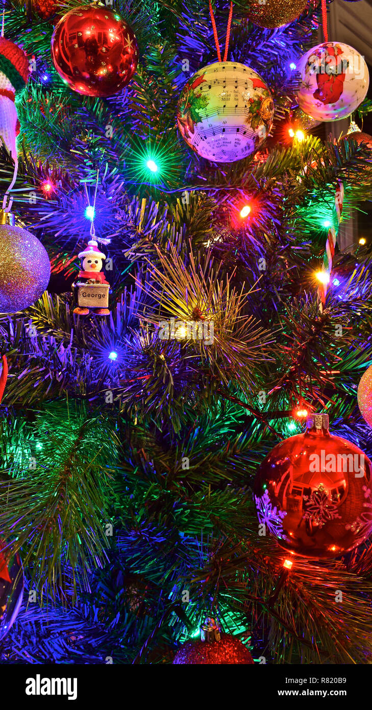 Colores brillantes luces y adornos del árbol de Navidad, incluyendo un  especial uno personalizado para George Fotografía de stock - Alamy