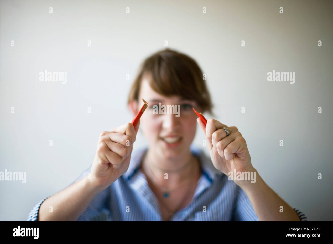 El lápiz se ajusta por una joven mujer adulta. Foto de stock