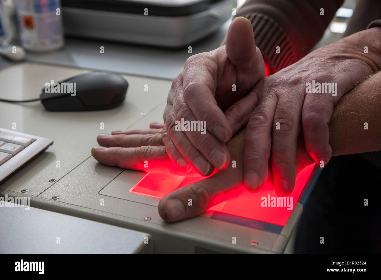 Las huellas dactilares y palmares impresiones de una persona sospechosa se graban con un escáner, Alemania Foto de stock