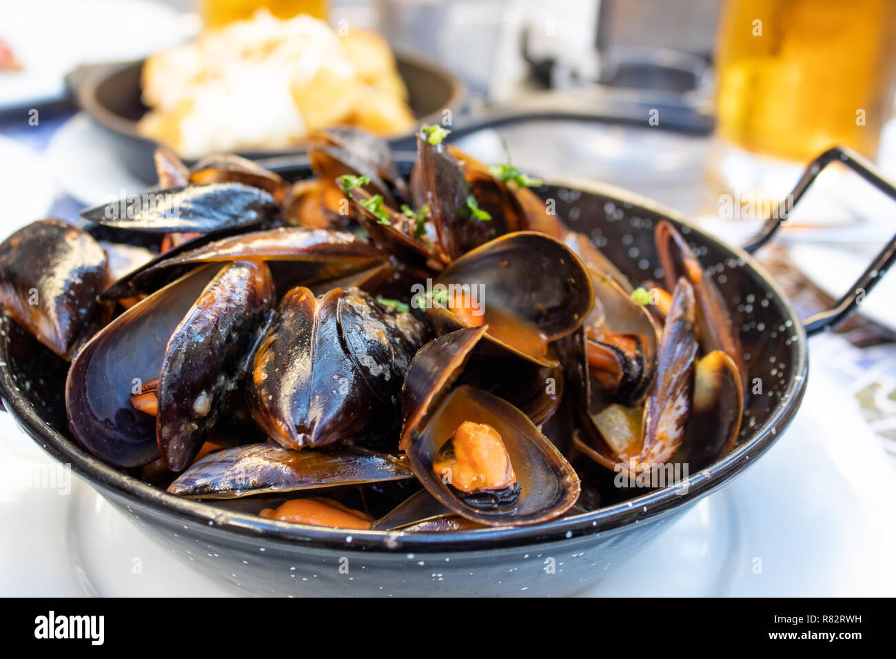 Mejillones en salsa de tomate, servido en una sartén Foto de stock