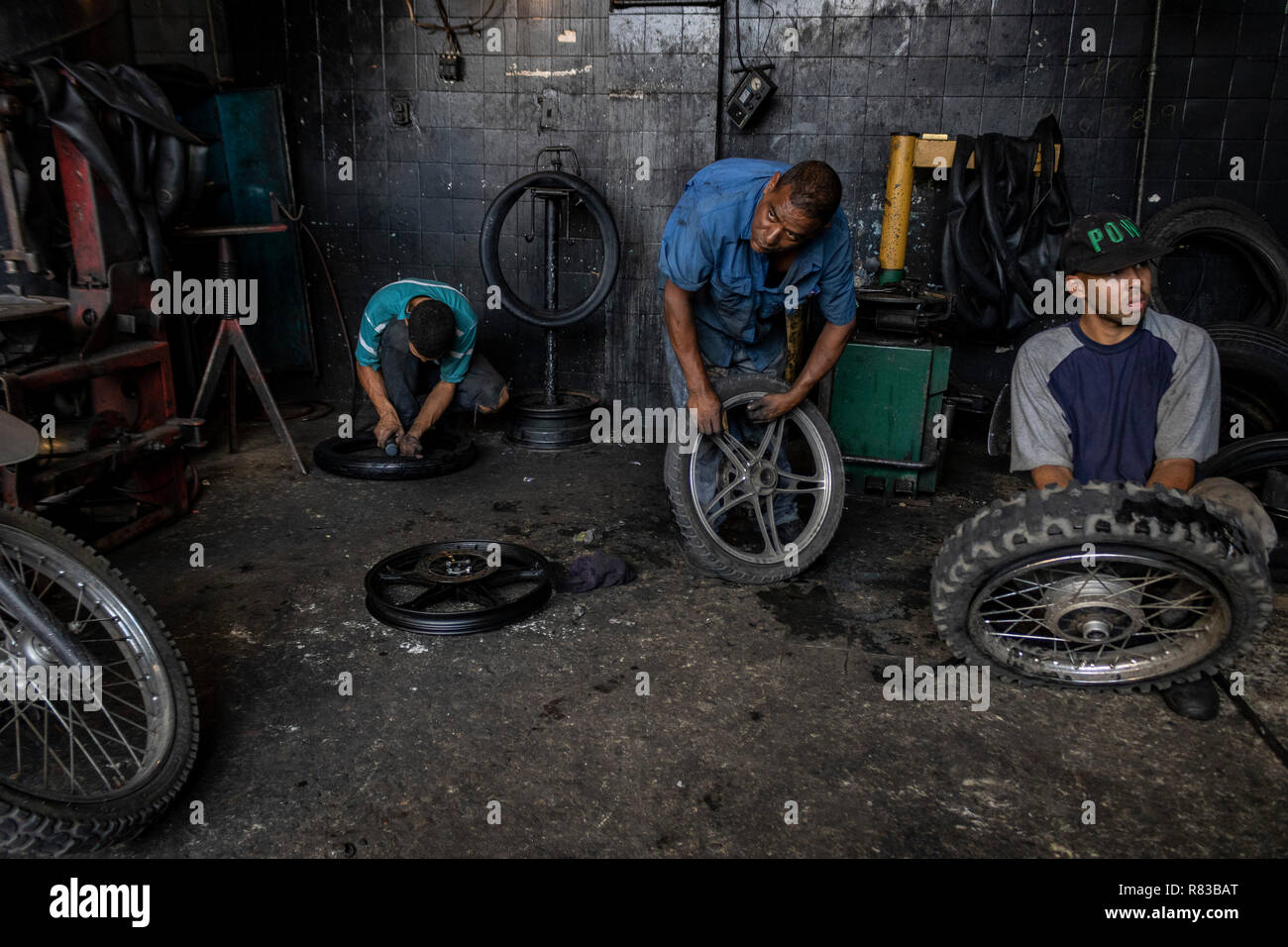 Caracas, Venezuela. 11 Dec, 2018. Los venezolanos abrigos de reparación en un taller. En vista de la crisis económica, todo en Venezuela está siendo reparado hasta es absolutamente inútil. El mercado interno venezolano está sufriendo enormemente debido a la crisis económica. Según el Fondo Monetario Internacional (FMI), el país sudamericano se encamina a una inflación de 1,37 millones por ciento en 2018. Crédito: Rayner Peña/dpa/Alamy Live News Foto de stock