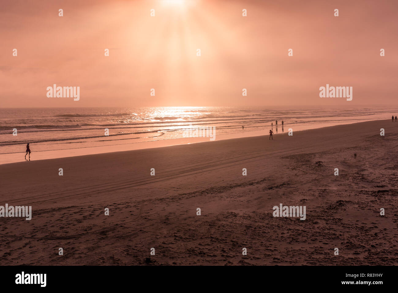 Silueta de personas jugando y caminar en la playa de Florida Foto de stock