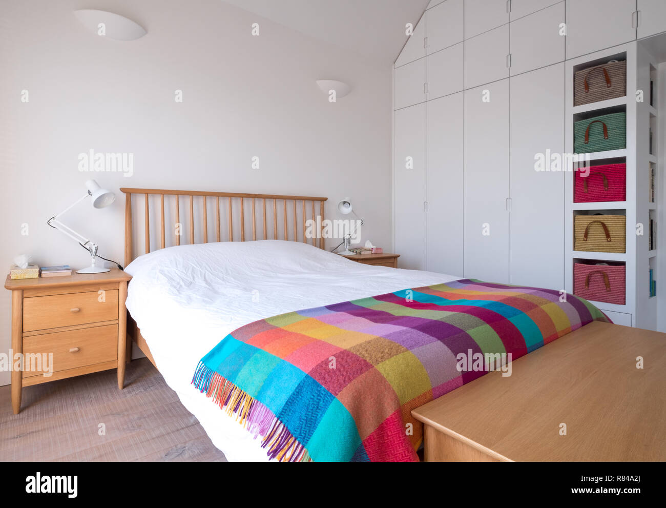 Scandi, de estilo minimalista, despejada interior del dormitorio con muebles  de dormitorio de madera, paredes blancas, ropa de cama blanca y las  coloridas cestas de rafia Fotografía de stock - Alamy