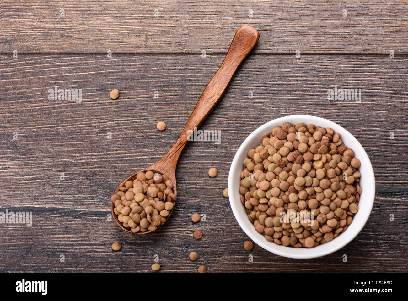 La lenteja verde canadiense grande con alto contenido proteico. Cuchara de  madera con lentejas. Copie el espacio. Diseño de borde Fotografía de stock  - Alamy