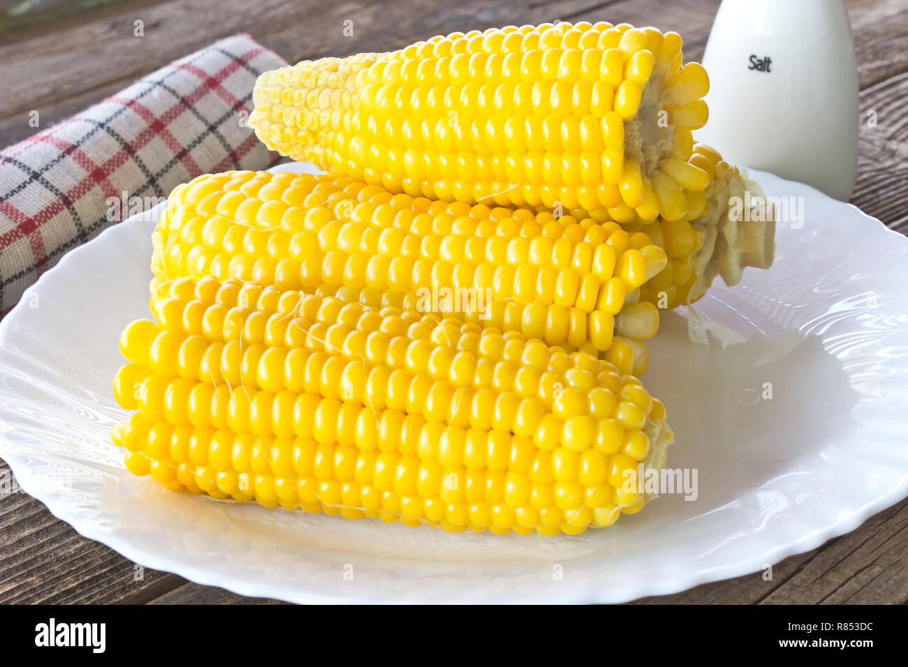Las mazorcas de maíz cocida en la placa sobre la mesa de madera Foto de stock
