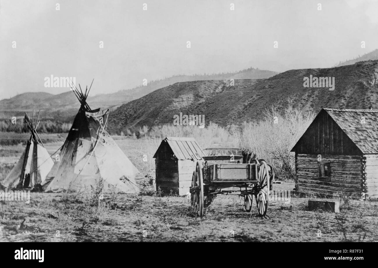 Dos Tipis, pequeñas construcciones de madera y colinas de Buggy, en el fondo, Agencia Colville, Washington, EE.UU., National Photo Company, 1910 Foto de stock