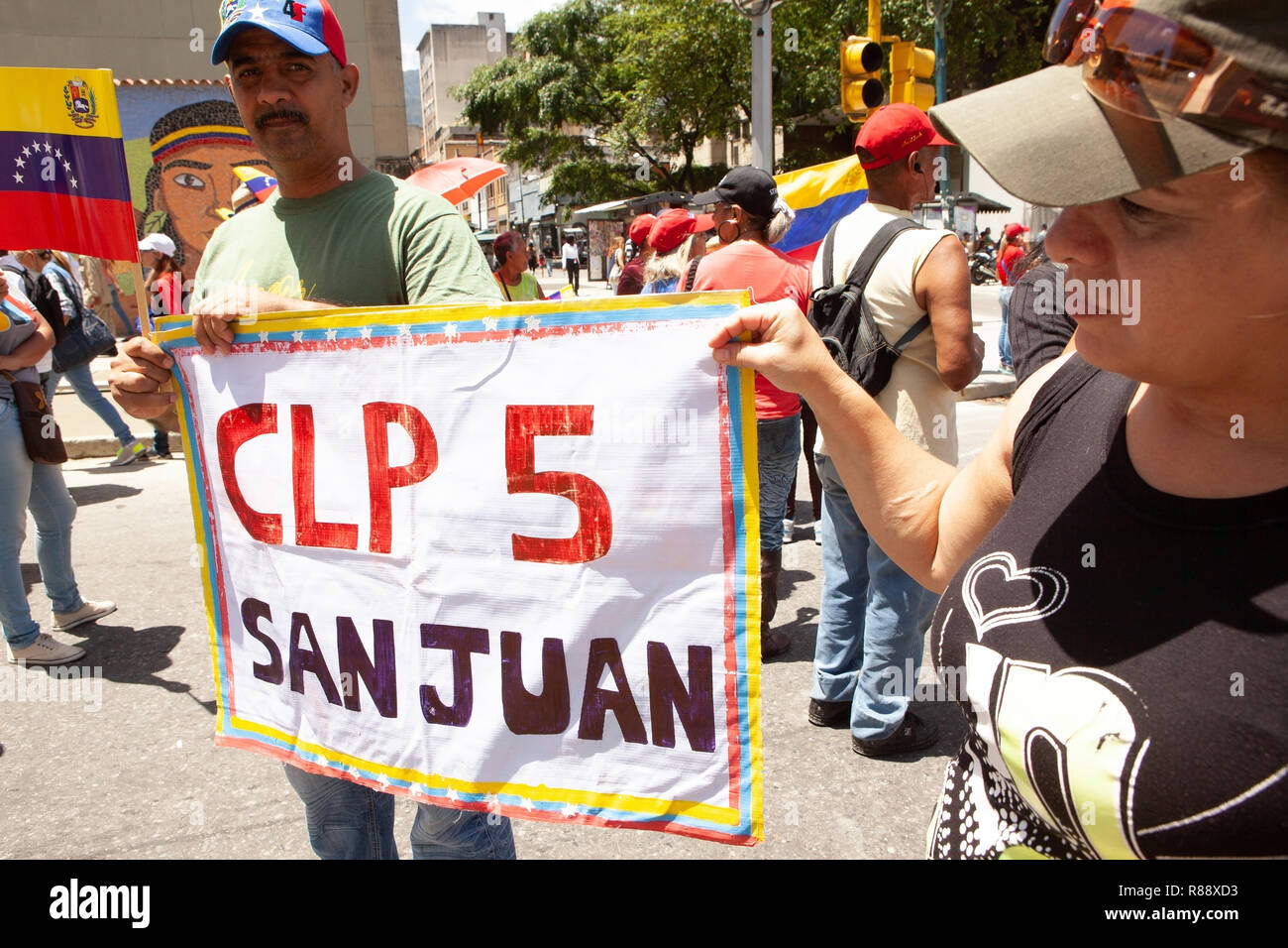 Los venezolanos marchan en ciudad llevando CLP y póster de San Juan bandera venezolana, Caracas, Venezuela, Sudamérica Foto de stock
