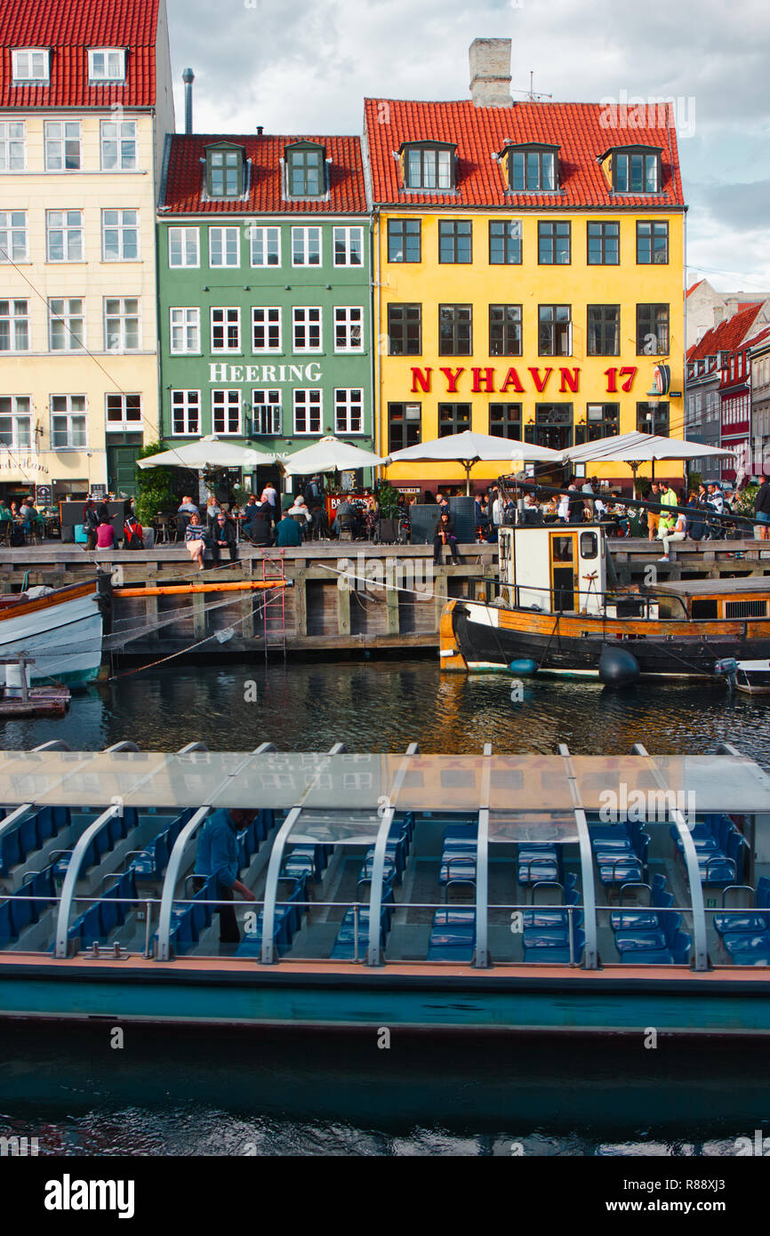 Adosados, cafés, bares, restaurantes y una terraza para comer al fresco junto al Canal de Nyhavn, Nyhavn, Copenhague, Dinamarca, Escandinavia Foto de stock