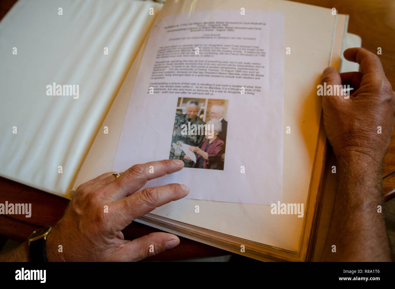 Carel Boshoff (junior) el nieto de H.F. Verwoerd, el genio del apartheid, está mirando un álbum de fotos de una 1995 visita del Presidente de Sudáfrica, Nelson Mandela, en Orania, El Cabo Septentrional, Viernes, 12 de diciembre de 2013. Foto: Eva-Lotta Jansson Foto de stock