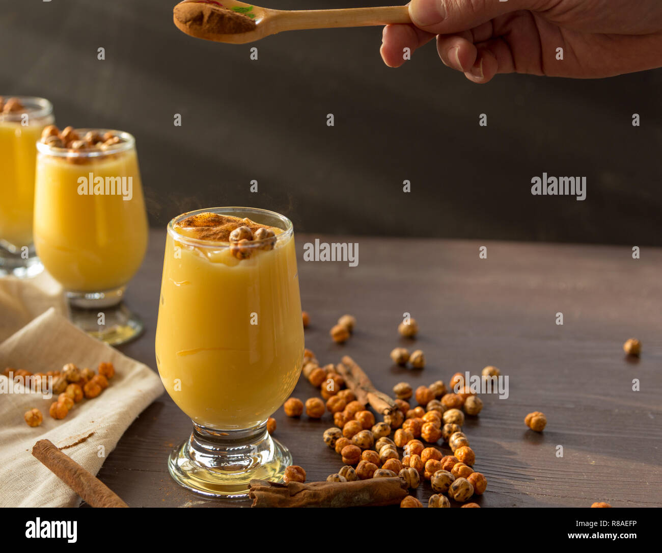 Boza o bosa, una bebida tradicional turco garbanzos tostados y canela en la tabla marrón Foto de stock
