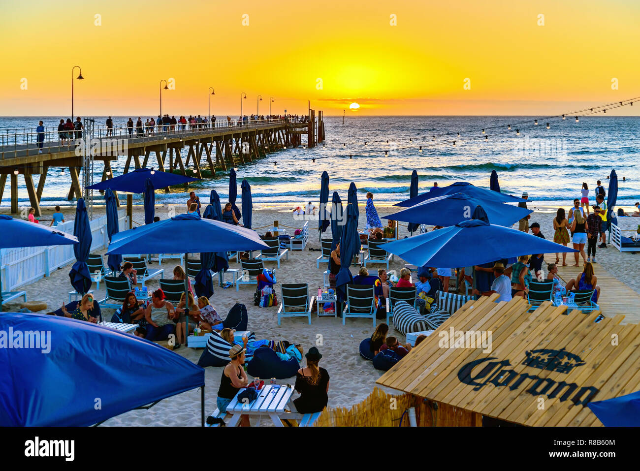 Adelaida, Australia del Sur - Marzo 11, 2018: la gente en el Moseley Beach Club café disfrutando de la vista del atardecer en una noche de verano Foto de stock