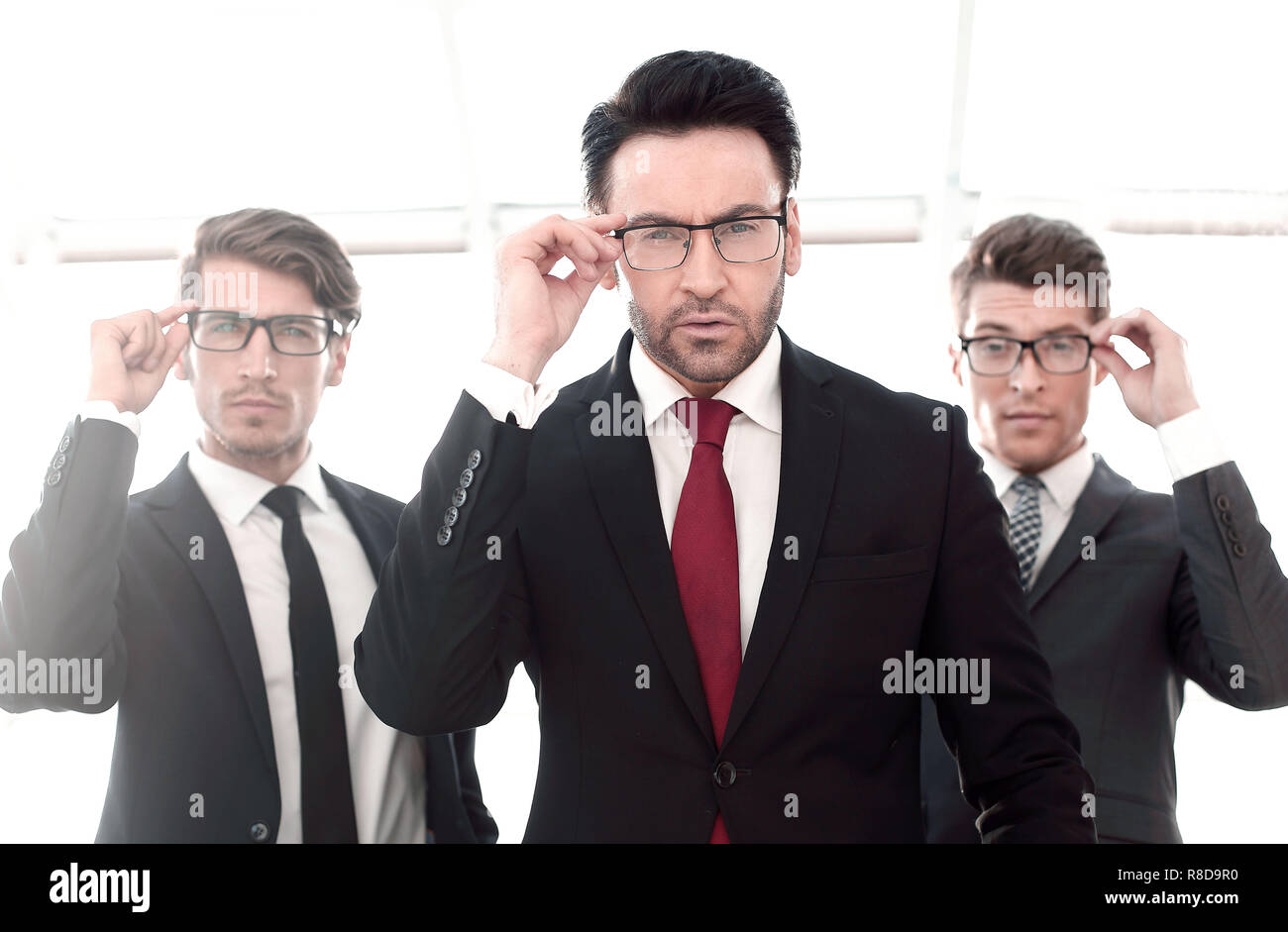 Tres empresarios con gafas, pretencioso mirando la cámara Foto de stock