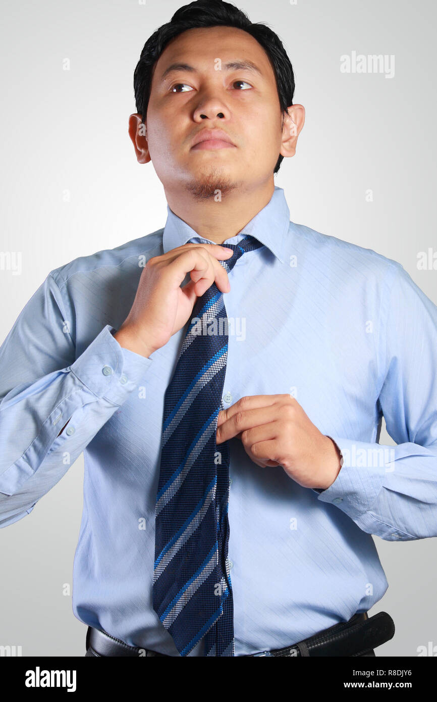 Imagen de Foto retrato de un guapo atractivo joven exitoso empresario asiático ajustar su neck tie Foto de stock