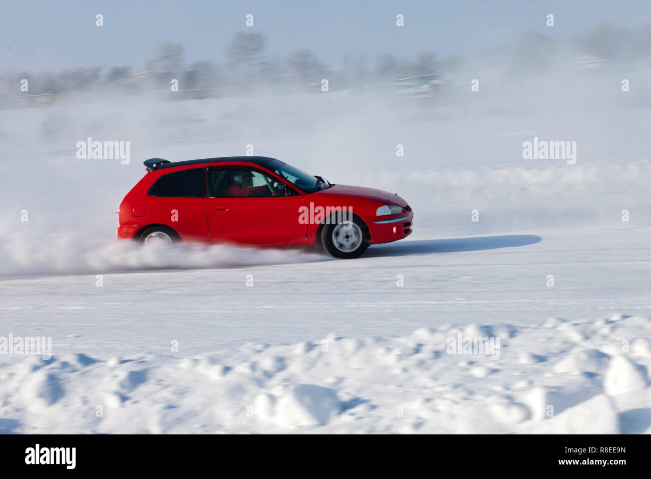 Coche rojo moviéndose sobre hielo con antecedentes blured Foto de stock