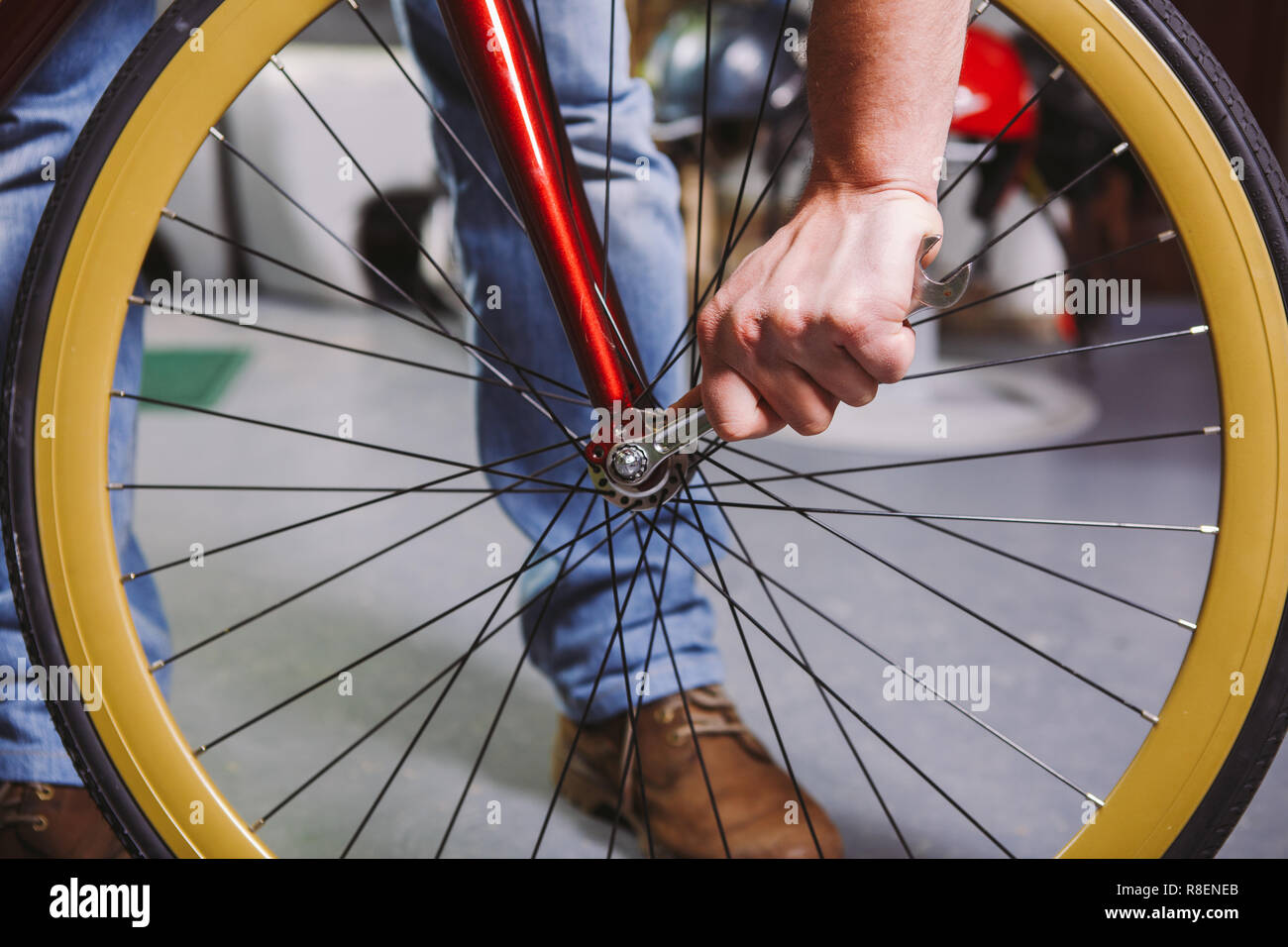 Tema reparación de bicicletas. Close-up de la mano de un hombre caucásico  utilizar una herramienta de mano Herramientas bicicleta cono del cubo Wrenc  para ajustar e instalar versiones rápidas y Thru o
