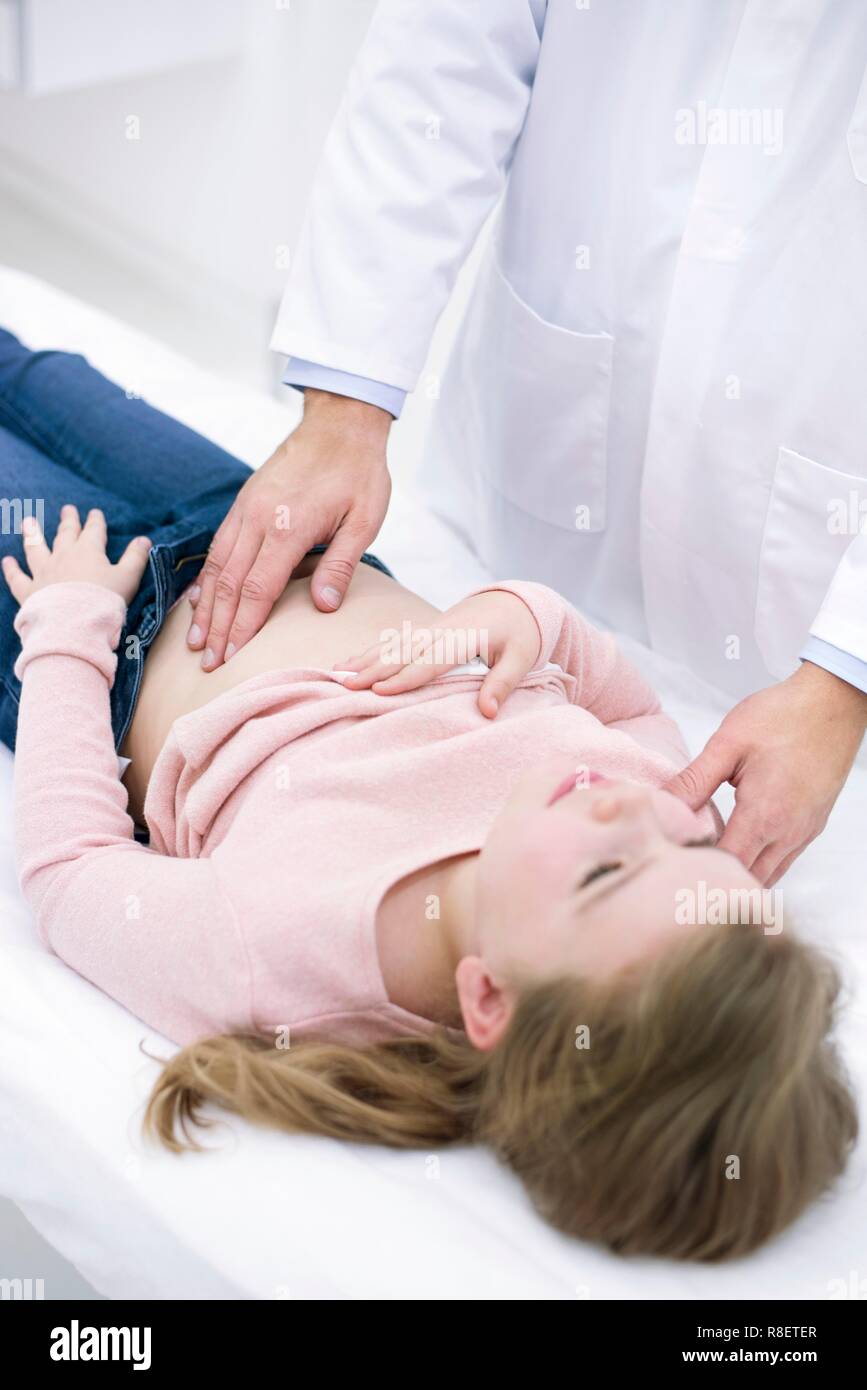 Médico examina chica del abdomen Foto de stock