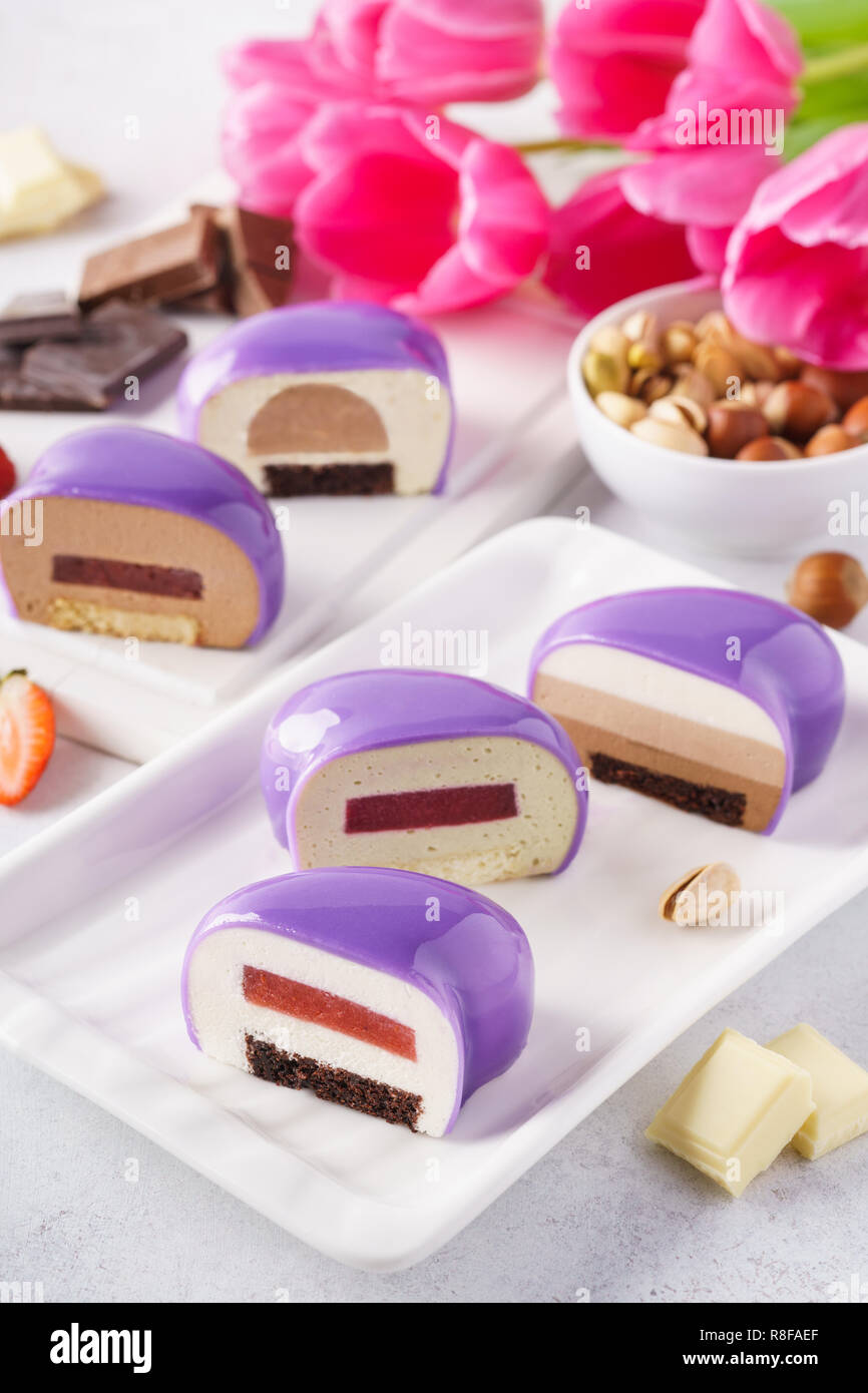 Conjunto de violeta o púrpura en forma de corazón tortas de mousse con diferentes rellenos. Foto de stock
