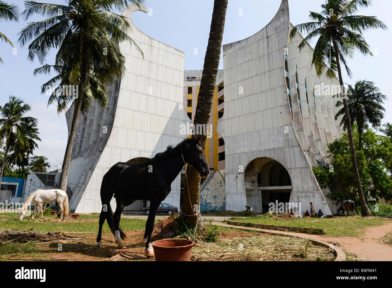 TOGO, Lomé, desde 2005 han abandonado el Hotel de la Paix en Boulevard du Mono, construido en el año 1970'íes y gestionado por PULLMAN Group, en frente de la playa de pastoreo caballos / verlassenenes Hotel des Friedens, davor grasende Strandpferde Foto de stock