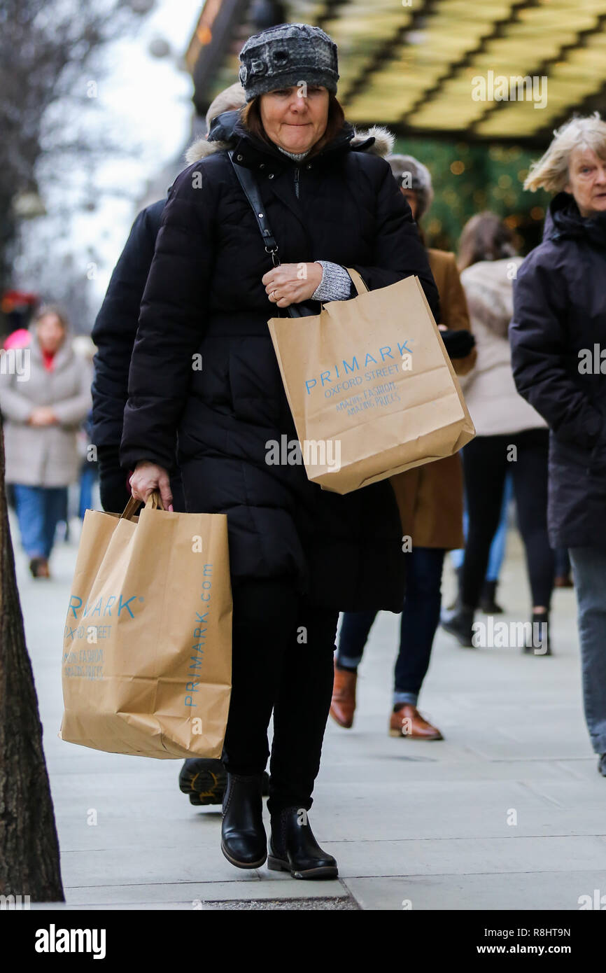 Una mujer es visto con bolsas de Primark de Londres, Oxford Street, con  bolsas de compras con 9 días al día de Navidad. Los minoristas esperan una  avalancha de compradores en el