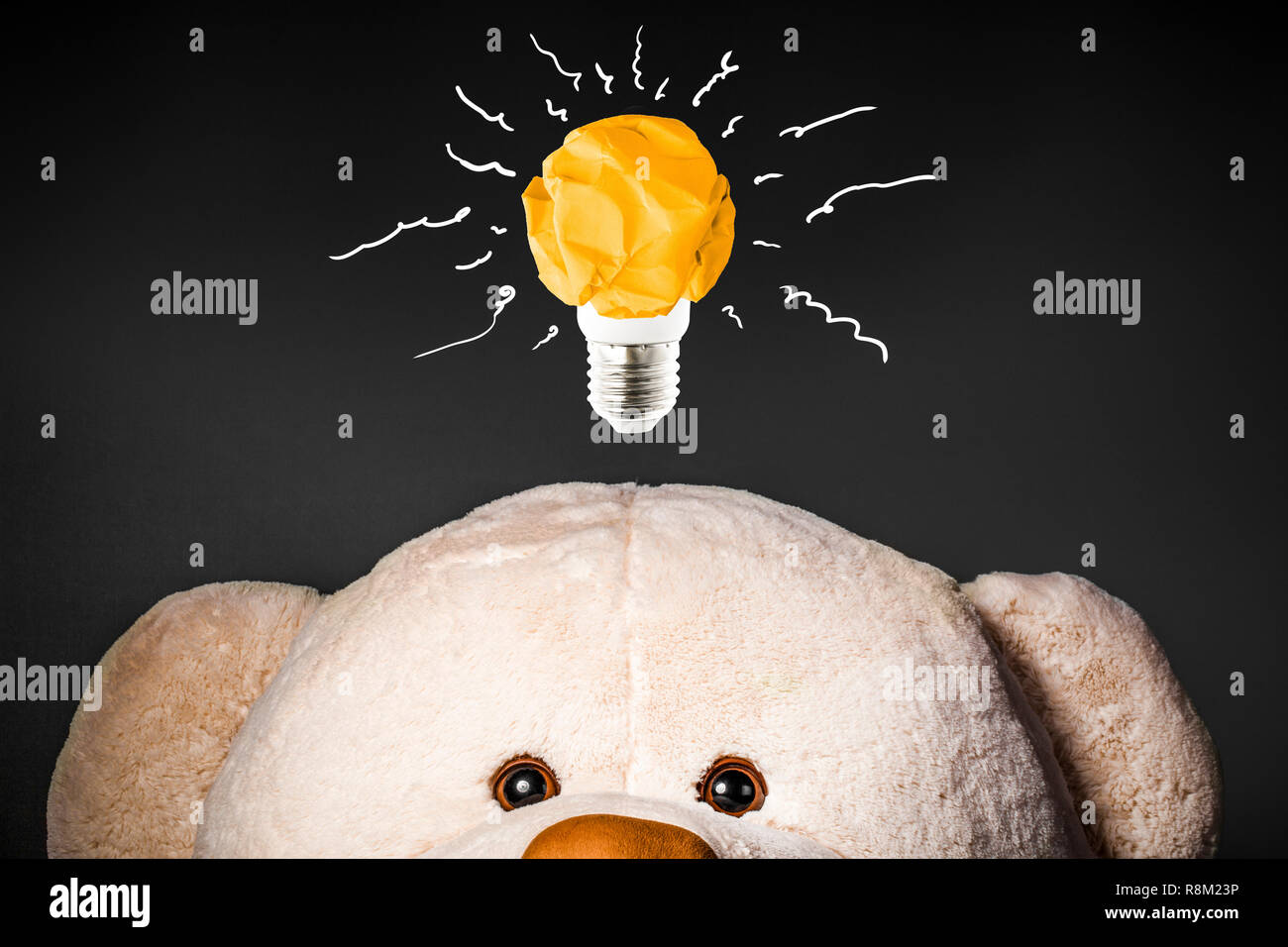 Oso de juguete con papel amarillo arrugado en forma de una bombilla en la  parte superior, concepto Fotografía de stock - Alamy