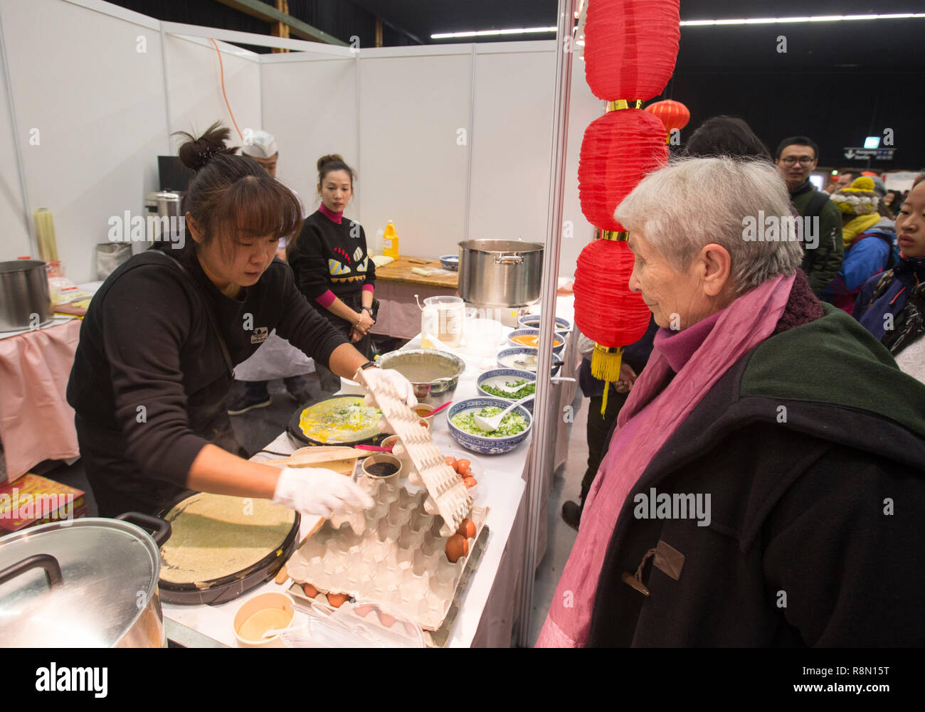 (181216) -- Berna, Diciembre 16, 2018 (Xinhua) -- Una mujer local espera para degustar crepe chino durante el Festival de la cultura de la comida china en Berna, capital de Suiza, el 16 de diciembre, 2018. El primer Festival de la cultura de la comida china se celebró el domingo en el interior del Bernexpo aquí en la capital suiza, atrayendo a más de 1.000 residentes locales en la fiesta de Navidad. Los visitantes disfrutaron de bocadillos chinos así como espectáculos tradicionales incluyendo la caligrafía, canciones folclóricas y artes marciales, durante el día de festival, apoyado por la Embajada de China y patrocinado por diversas asociaciones locales. (Xinhua/Xu Jinq Foto de stock