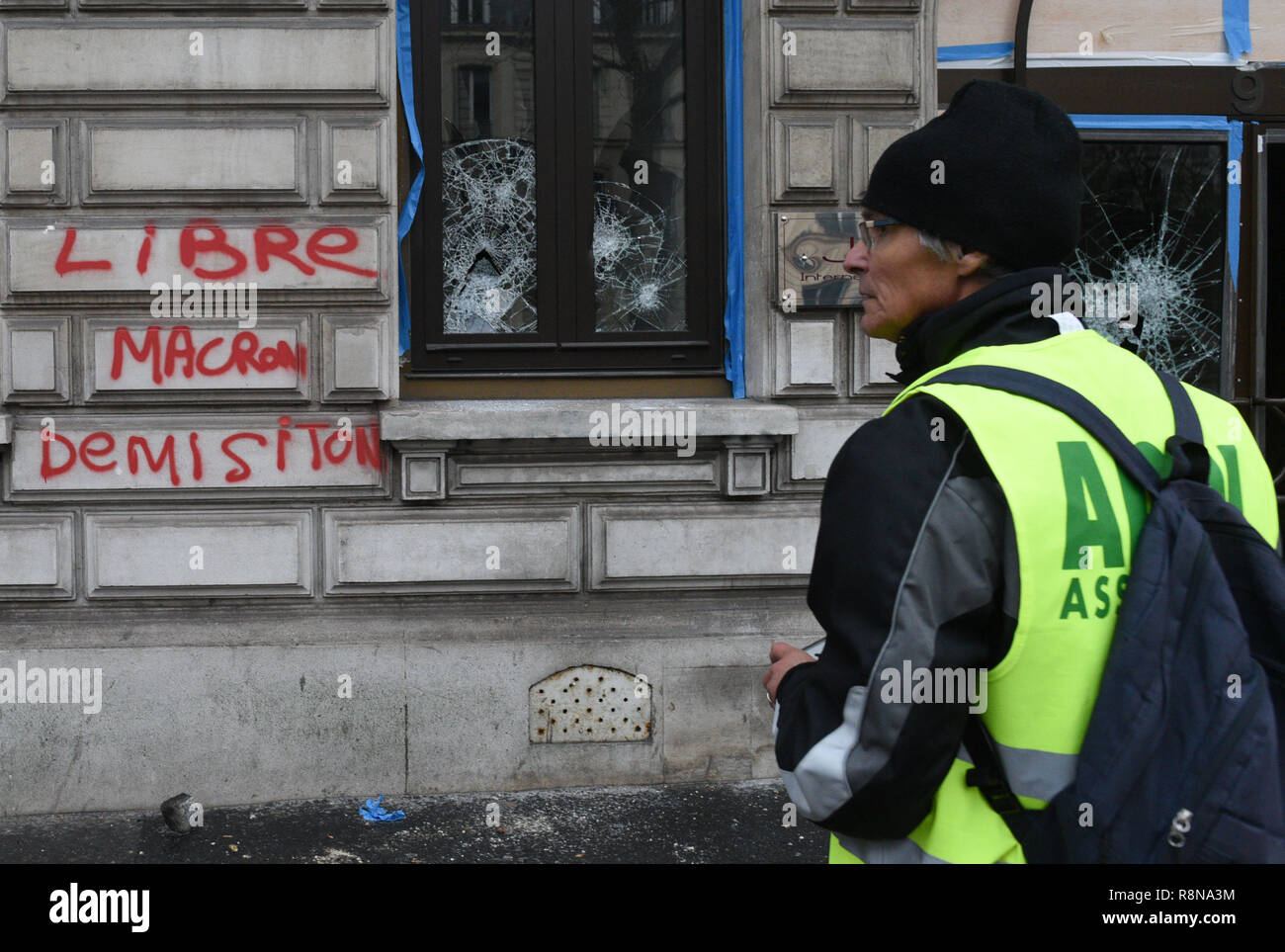 Diciembre 08, 2018 - París, Francia: un graffiti pidiendo la dimisión de  Macron cerca de ventanas rotas. Varias tiendas se han dañado cerca de los  Campos Elíseos avenue como chalecos amarillos protestaron