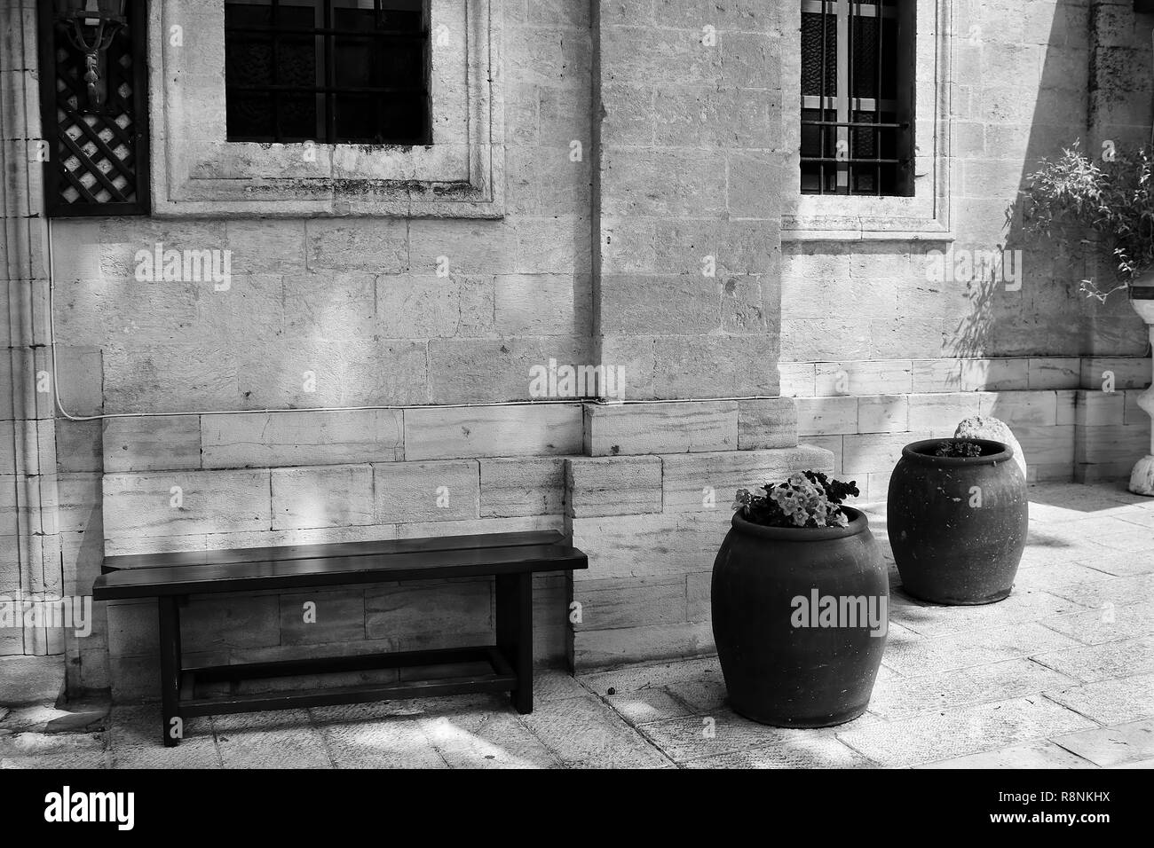 Banco y cuencos de vino con flores cerca de la iglesia ortodoxa griega Cana  bodas de Caná de Galilea, Kfar Kana, Israel. Filtro blanco y negro  Fotografía de stock - Alamy