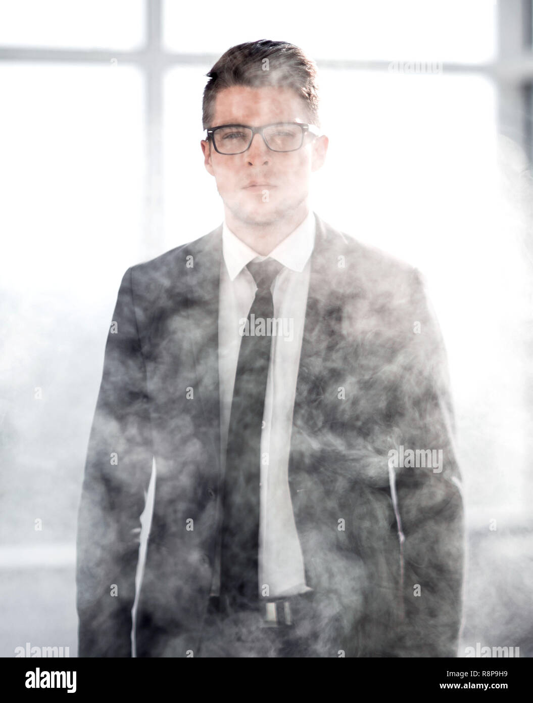 Joven empresario en una oficina ahumado Foto de stock