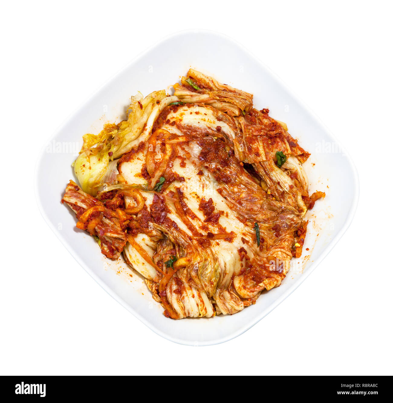 Cocina coreana - Vista anterior del aperitivo kimchi (repollo napa Spice) en blanco recipiente aislado sobre fondo blanco. Foto de stock