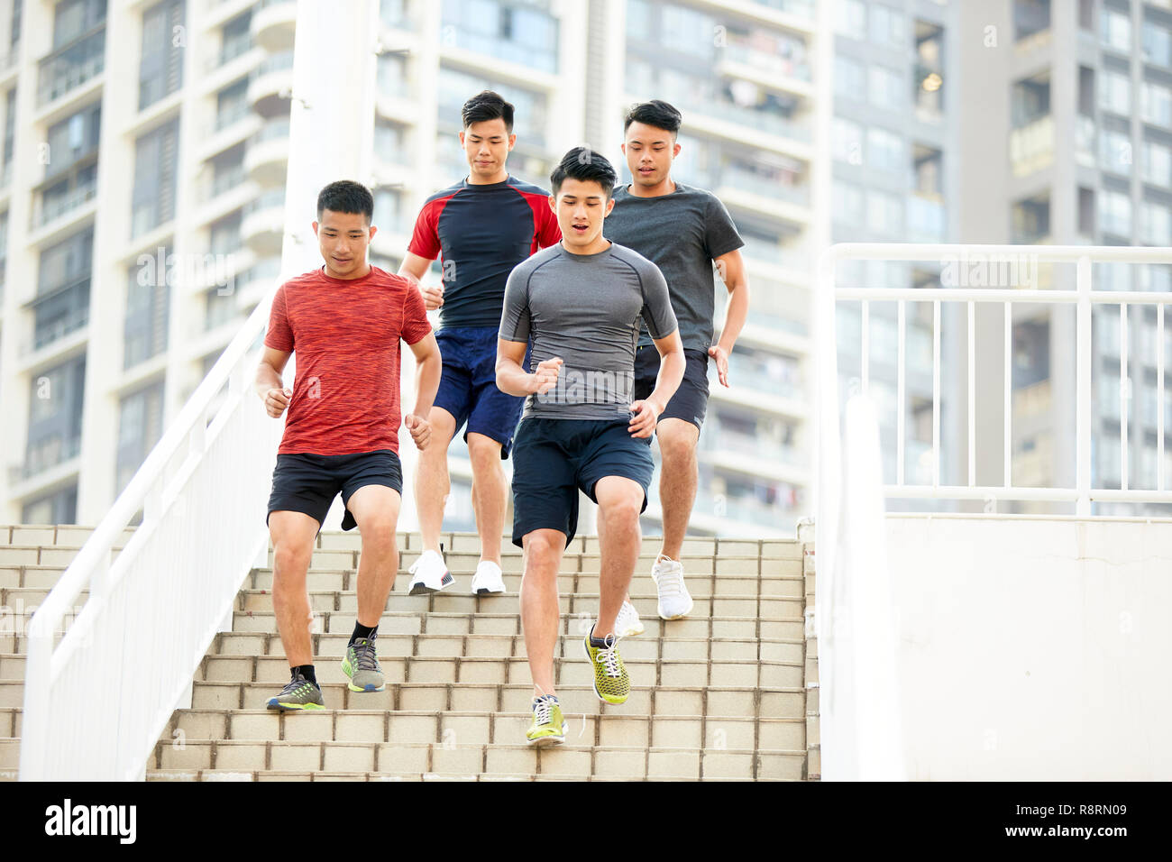 Los jóvenes hombres asiáticos entrenamiento running en pasos al aire libre. Foto de stock