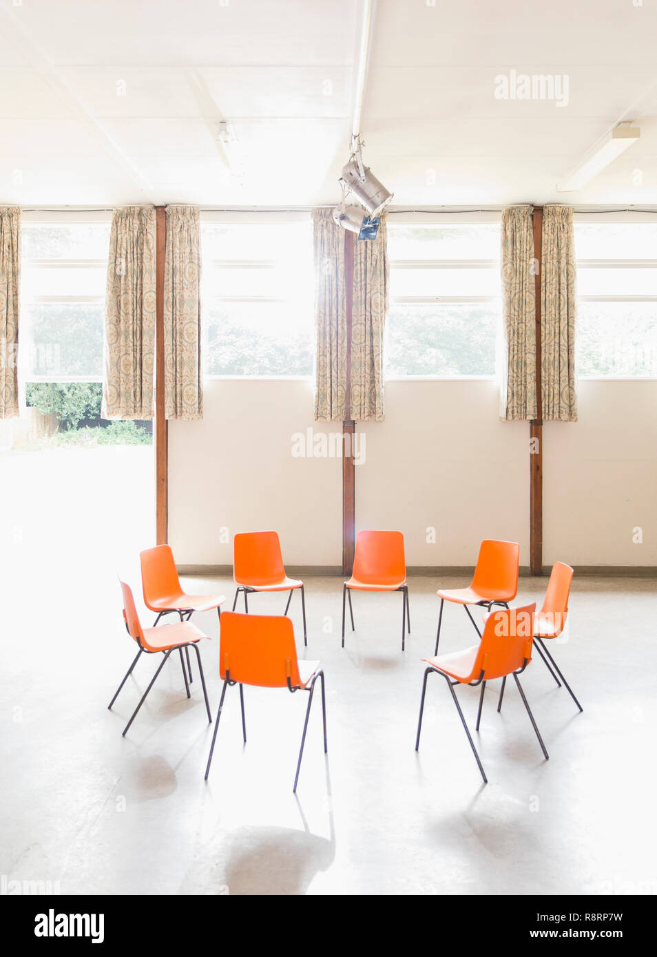 Naranja sillas dispuestas en círculo en el centro comunitario Foto de stock
