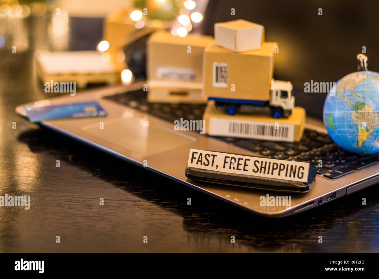 Rápido envío gratis - bodegón logística concepto de negocios con ordenador portátil, teléfono, mini cajas de envío Foto de stock