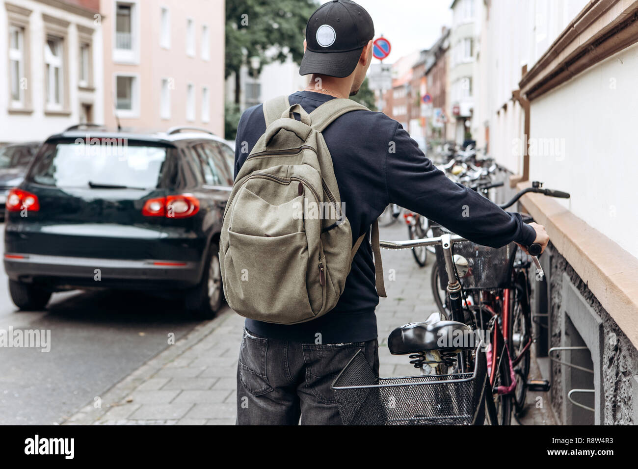 Turista o estudiante con una mochila va a montar una bicicleta. Foto de stock
