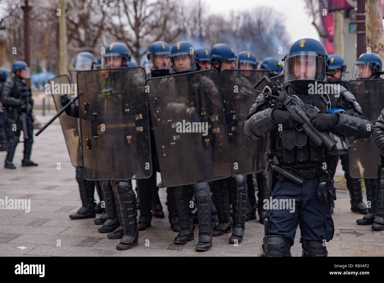 La policía antidisturbios chalecos amarillos para la demostración (Gilets Jaunes) de los manifestantes contra el gobierno, y el Presidente francés en los Campos Elíseos, en París, Francia Foto de stock