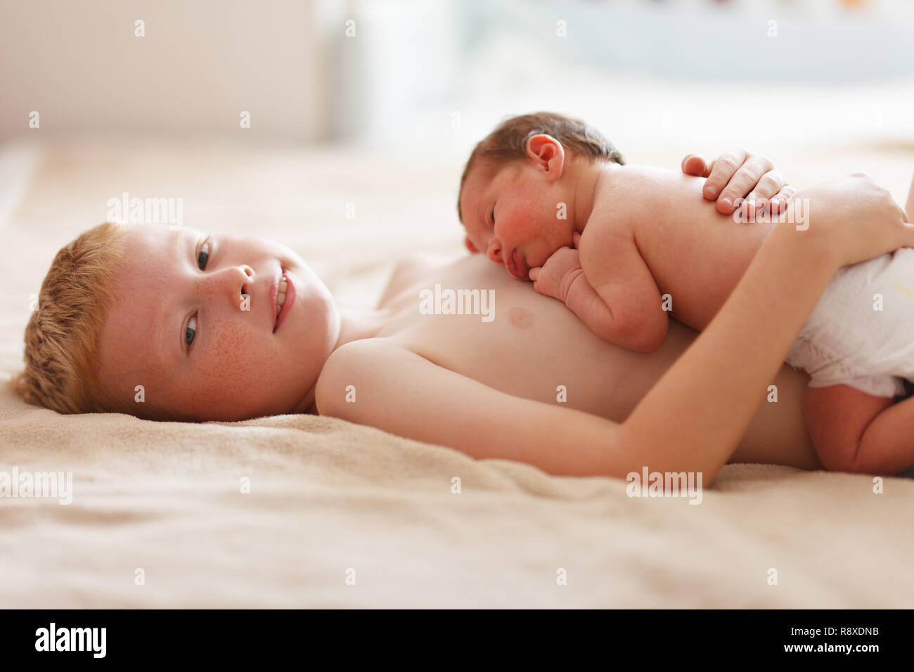 Nueve años chico juega con su hermanito Foto de stock