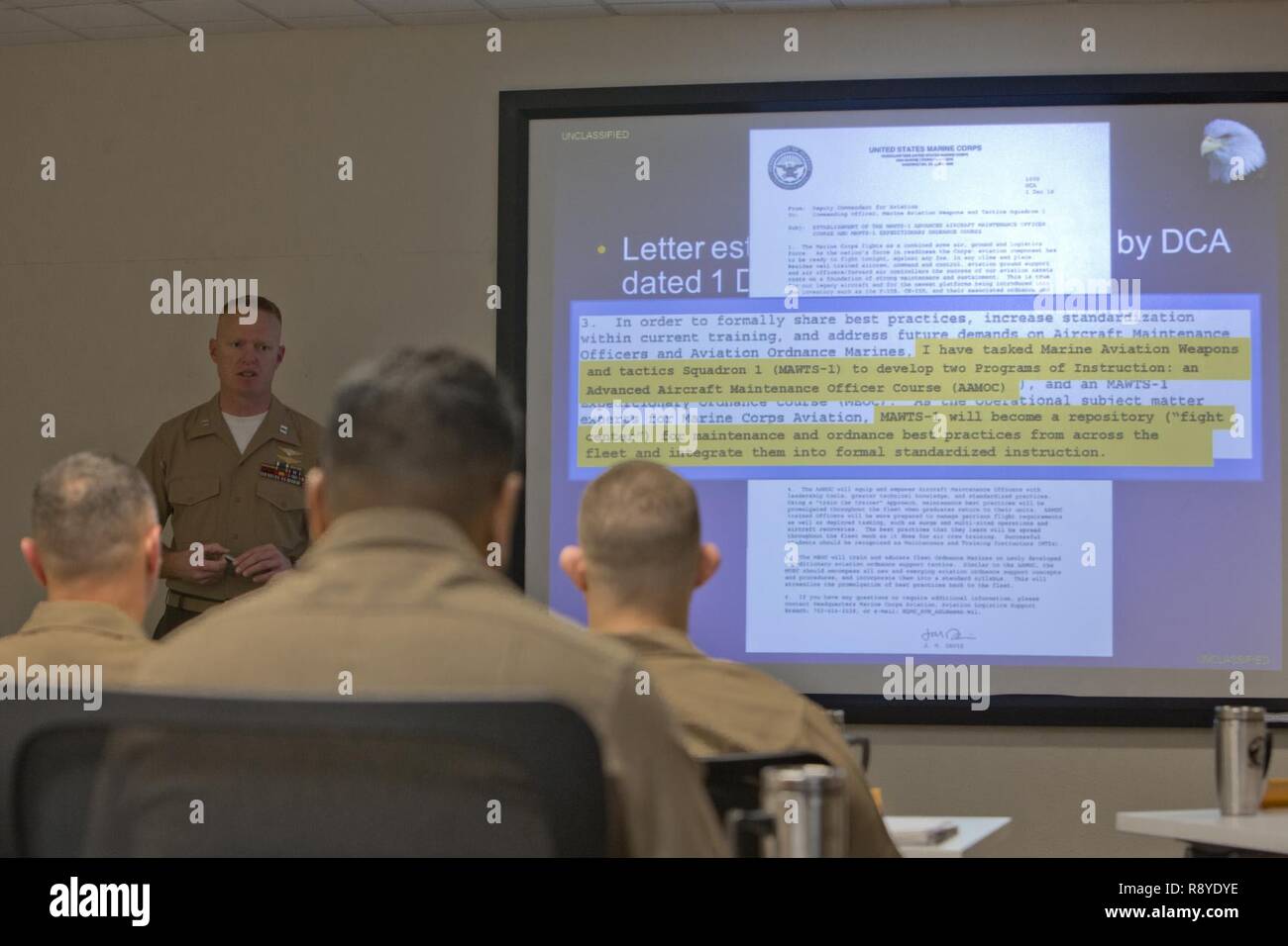 El capitán de marina de los EE.UU. Scott L. Campbell, oficial de mantenimiento con armas y tácticas de Aviación Marina Escuadrón uno (MAWTS-1) da la bienvenida a los estudiantes que asistieron al primer curso de oficial de mantenimiento de aviones avanzados (AAMOC) en Marine Corps Air Station Yuma, Arizona, el 13 de marzo, 2017. AAMOC capacitará a oficiales de mantenimiento de aeronaves con herramientas de liderazgo, mayores conocimientos técnicos y las prácticas normalizadas mediante procedimientos rigurosos de académicos y de capacitación práctica a fin de disminuir los percances relacionados con el suelo y aumentar la incursión de generación. Foto de stock