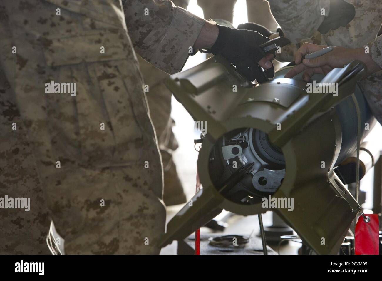 Marines estadounidenses con diversas marinas Escuadrón de Logística de la aviación (MALS) dan un período de instrucción en la unidad de bomba guiada 12 (GBU-12) durante el primer curso de oficial de mantenimiento de aeronaves (AAMOC) en Marine Corps Air Station Yuma, Arizona, el 17 de marzo de 2017. AAMOC capacitará a oficiales de mantenimiento de aeronaves con herramientas de liderazgo, mayores conocimientos técnicos y las prácticas normalizadas mediante procedimientos rigurosos de académicos y de capacitación práctica a fin de disminuir los percances relacionados con el suelo y aumentar la incursión de generación. Foto de stock