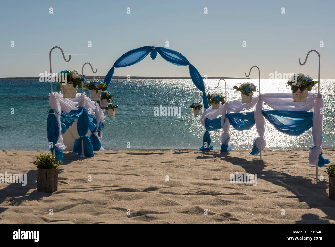 Configuración de boda matrimonio pasillo con cortinas y arco en Sandy Beach Paradise tropical al fondo del océano abierto Foto de stock