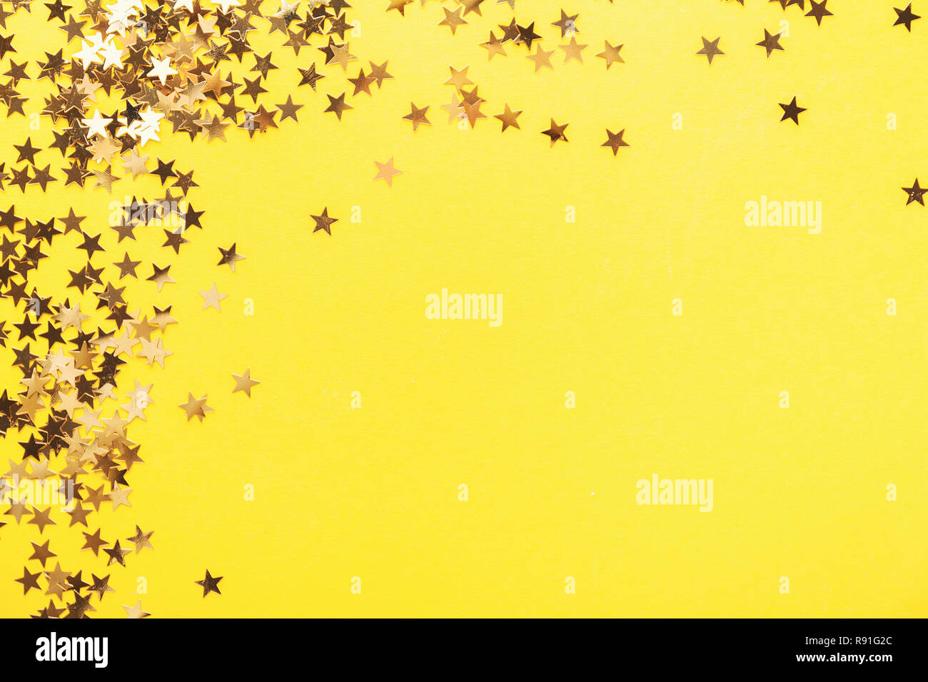 Estrellas brillantes dorados sobre fondo amarillo. Fiesta de Cumpleaños  Feliz Aniversario de fondo. Confeti de fondo Fotografía de stock - Alamy
