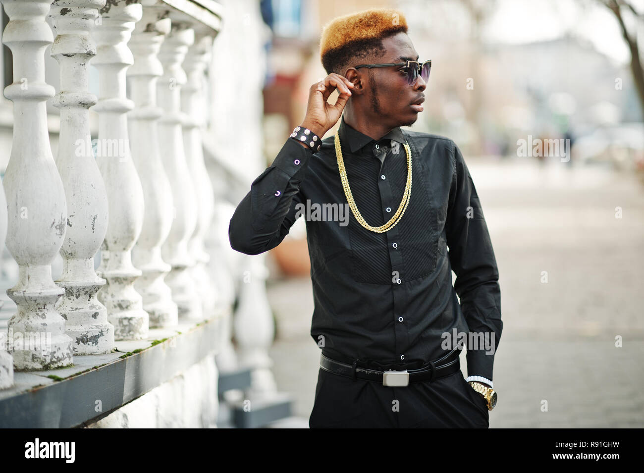 Chic apuesto hombre afroamericano en camisa negra con cadena de oro y gafas  de sol Fotografía de stock - Alamy