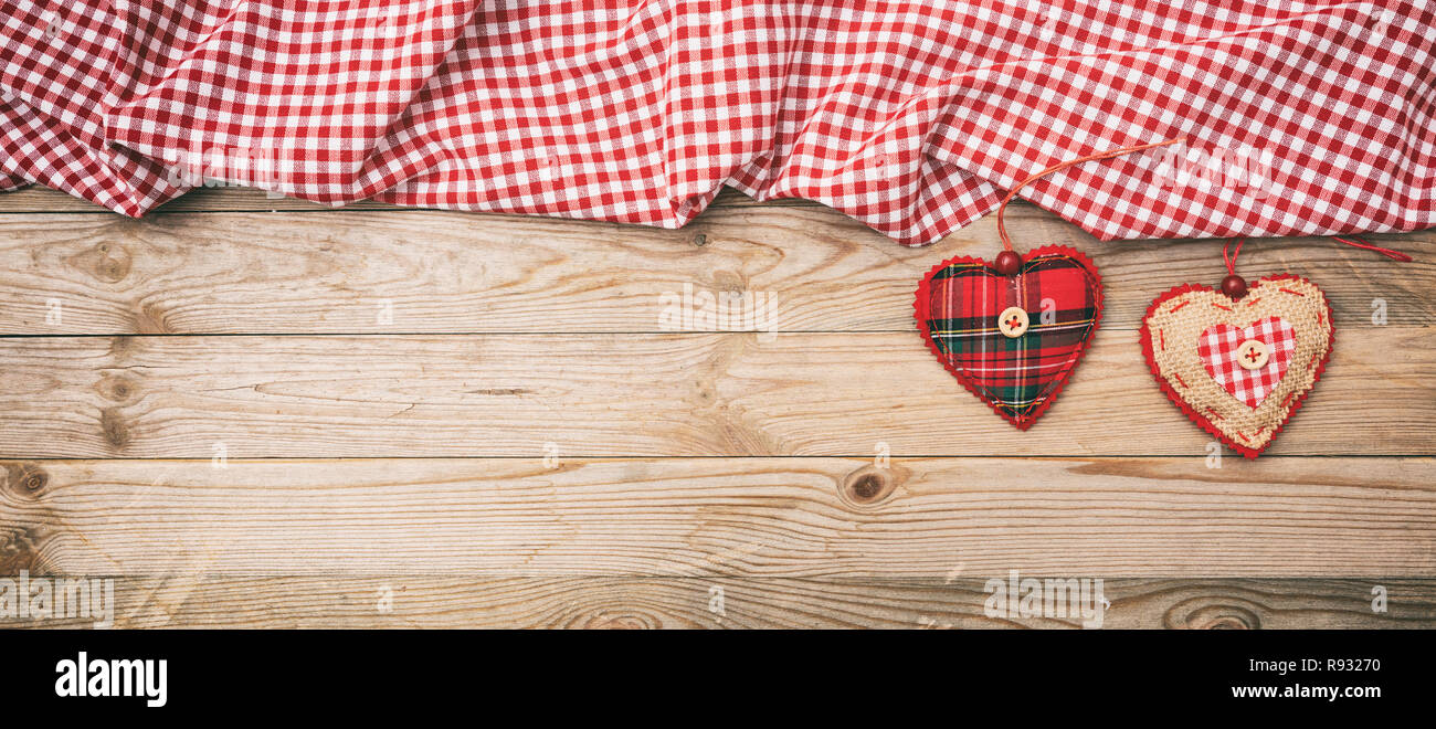 Día de San Valentín. Vista superior de corazones y de tela a cuadros blancos y rojos contra la tela de fondo de madera, copia el espacio, banner. Foto de stock