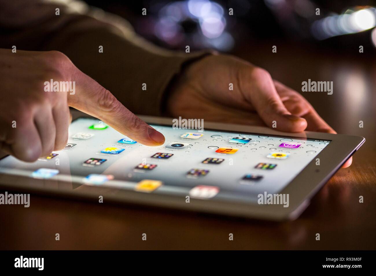 Dedo toca la pantalla táctil de un Apple iPad Foto de stock