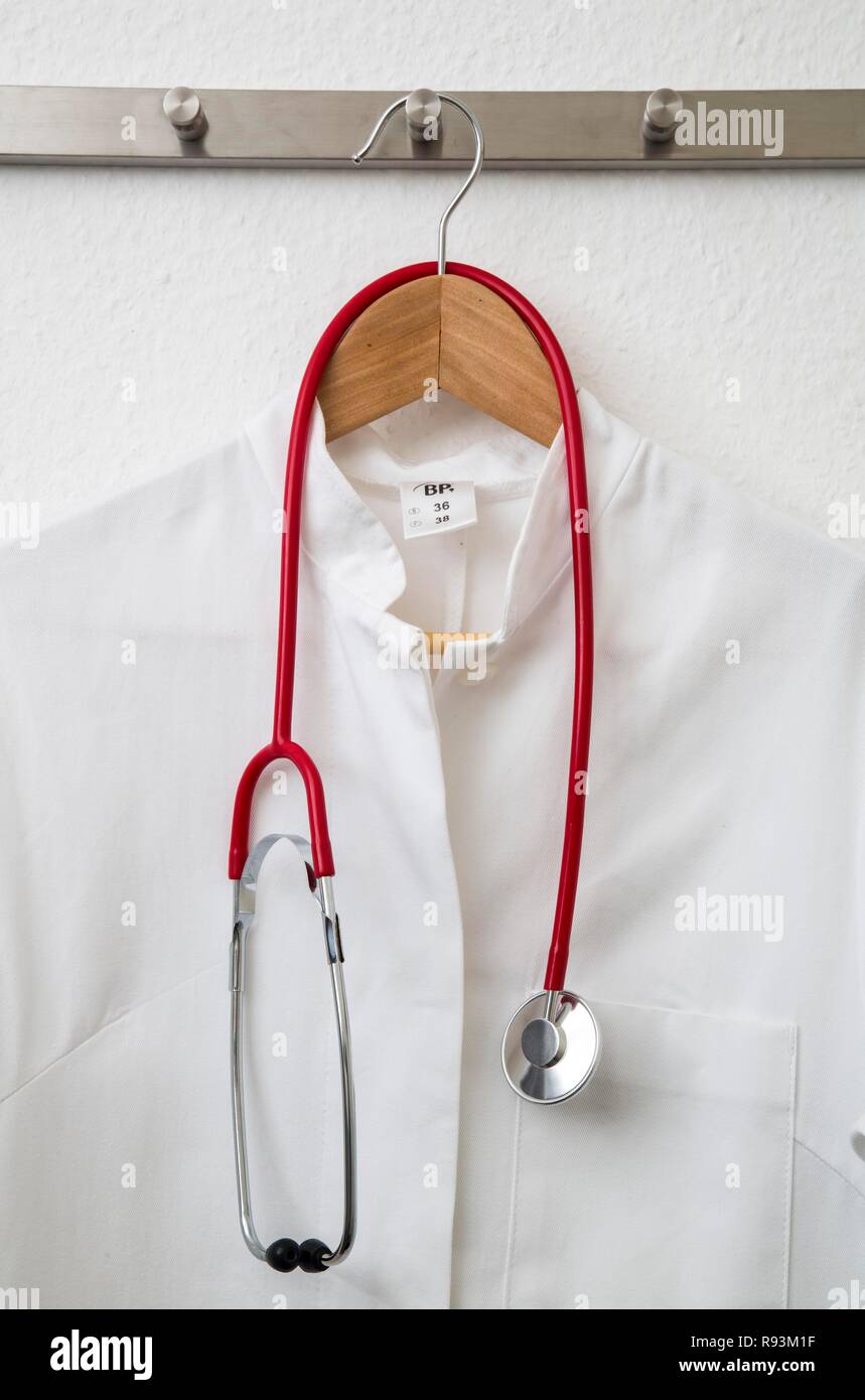 Escudo del médico colgado en una percha en un perchero con un estetoscopio Foto de stock