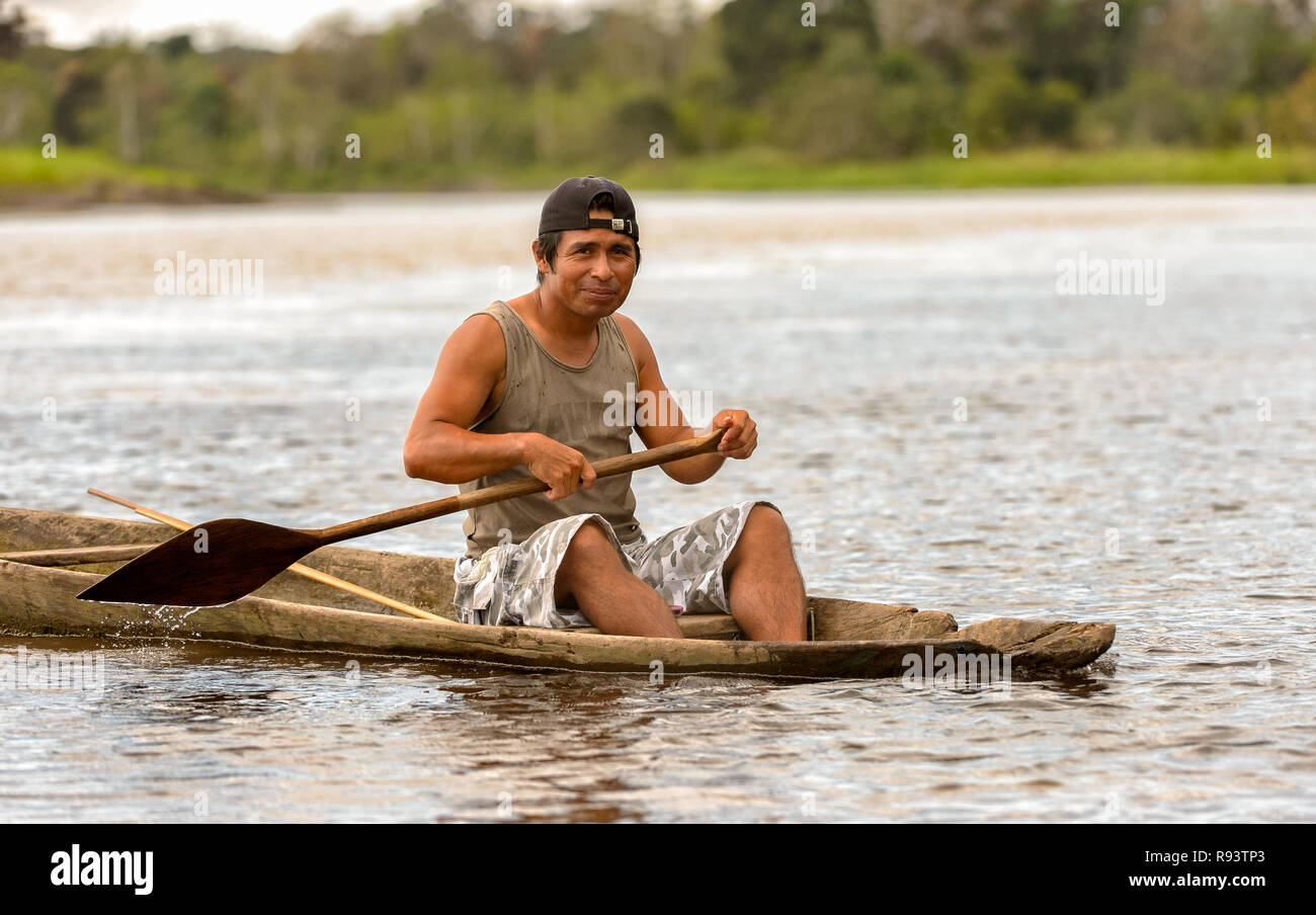 Un hombre local remando por el río Amazonas en su búsqueda de pescado Foto de stock