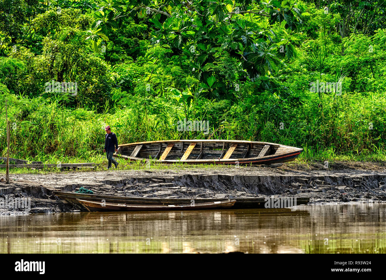 Reparación de la Canoa en el Río Amazonas Bank Foto de stock