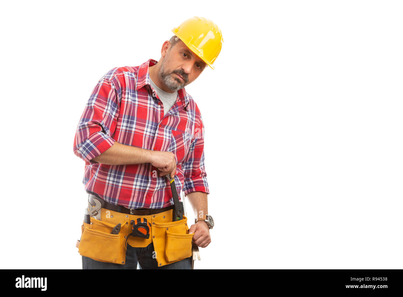 Constructor poniendo la llave en lugar de cinturón para herramientas en la cintura aislado sobre fondo blanco studio Foto de stock